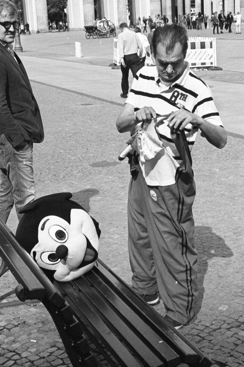 Ein Mann im Mickey-Mouse-Kostüm zieht sich um. Foto: Raimund Belling